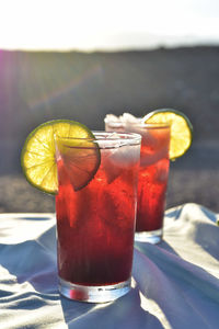 Cold drinks of iced tea made from hibiscus flower petal tea in hot desert setting