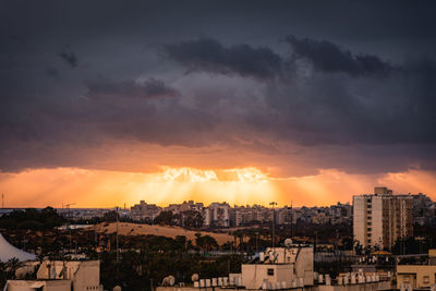 Silhouette cityscape against sky during sunset