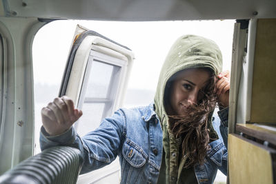 Teenage girl getting into vintage van on rainy day