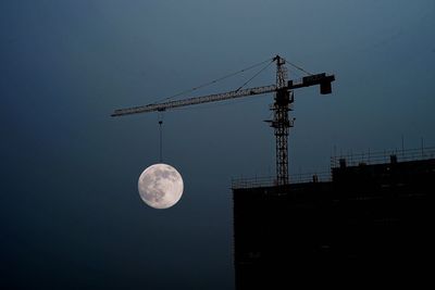 Low angle view of crane against sky