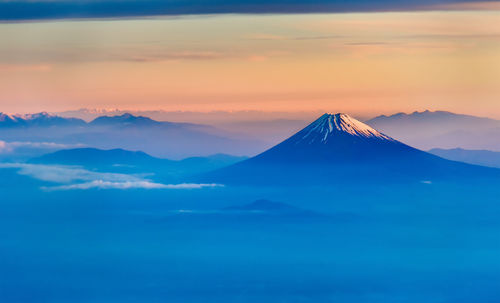 Scenic view of snowcapped mountains against sky during sunset