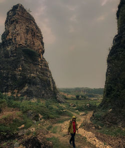 Rear view of woman standing on land against sky