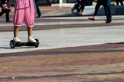 Low section of person riding motor scooter on street