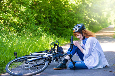 Woman in pain fallen from bicycle on road