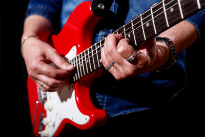 Midsection of man playing guitar