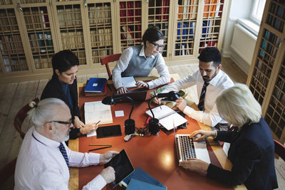 High angle view of professionals working at table in law library