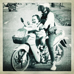 People riding motorcycle on road