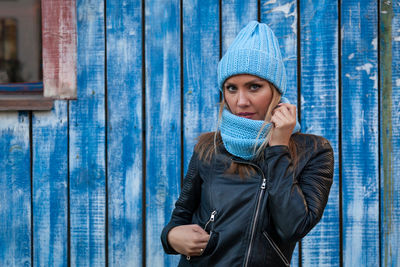 Beautiful modern urban young woman wearing blue knitting hat smile, look at the camera and enjoy