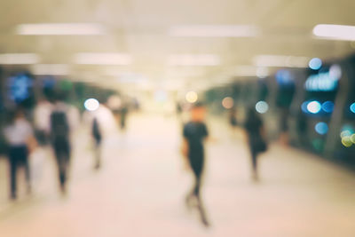 Defocused image of people walking in illuminated city