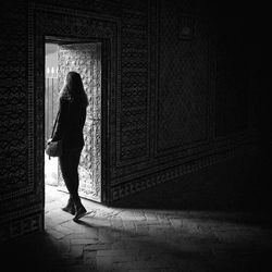 Rear view of woman standing amidst doorway in historic building