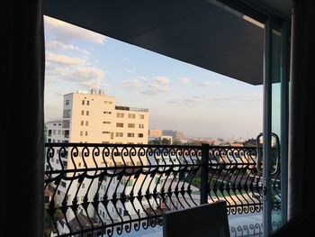 Buildings against sky seen through glass window