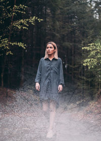 Double exposure of woman and trees in forest