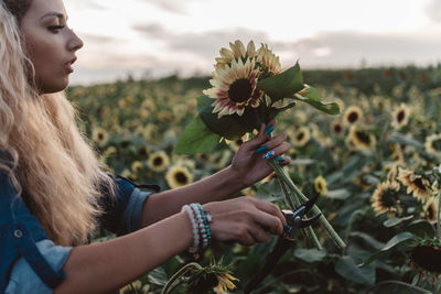 Midsection of woman holding flowering plant