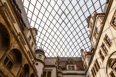 Low angle view of skylight in building against sky