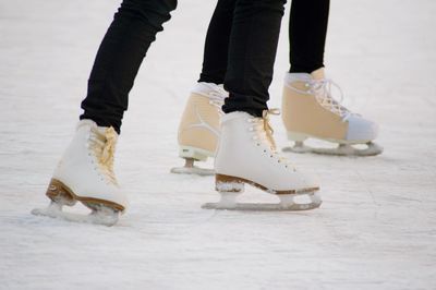 Low section of people ice-skating on rink