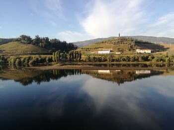 Scenic view of lake by buildings against sky