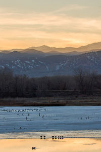 Scenic view of lake against sky during sunset