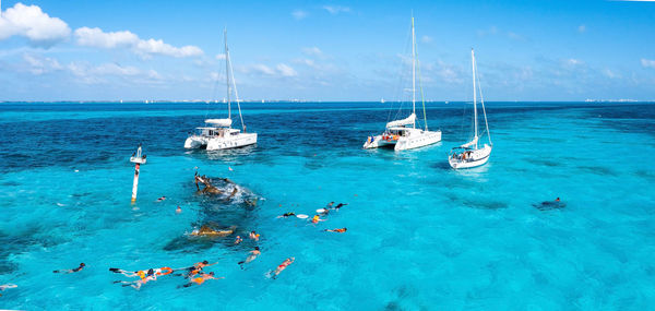 People snorkelling around the ship wreck near cancun in the caribbean sea.