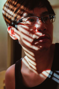 Close-up of mature man looking away while standing at home