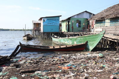 Abandoned boats moored on beach against sky