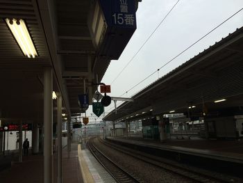 Train at railroad station in city against sky