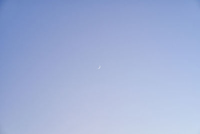 Low angle view of moon against clear blue sky