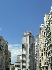 Low angle view of buildings against clear blue sky