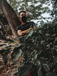 Low angle view of young man in forest