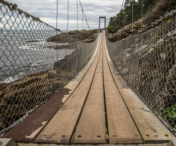 View of footbridge through chainlink fence