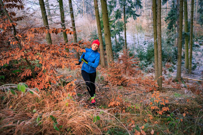 Man standing by trees in forest during autumn