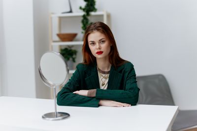 Portrait of young woman sitting on table