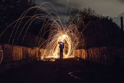 Man standing by wire wool at night