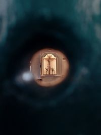 Close-up of illuminated building seen through hole