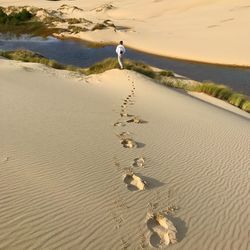 Rear view of man walking at desert