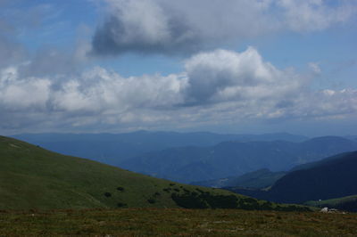 Scenic view of field and mountains against sky