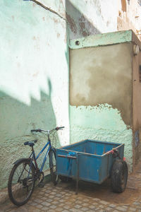 Bicycle parked against wall of old building