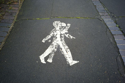 A double image of a painted person on a sidewalk