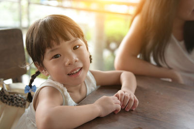 Portrait of cute girl sitting at home