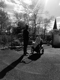 Father and son on street against sky