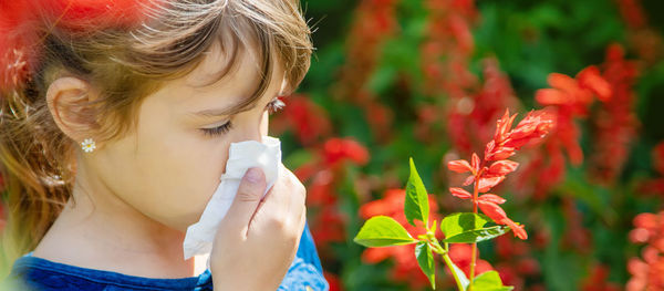 Close-up of girl wiping nose with tissue