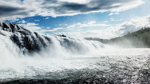 Scenic view of waterfall against sky