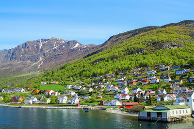 Scenic view of townscape by mountains against sky