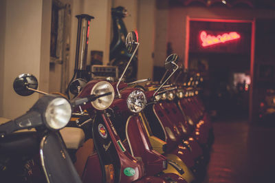 Motor scooters parked in dark showroom at night