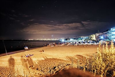 People on beach against sky at night