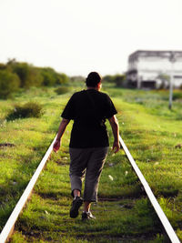 Rear view of man standing on grassy field