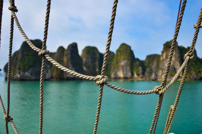 Close-up of ropes against sea and stack rocks at ha long bay