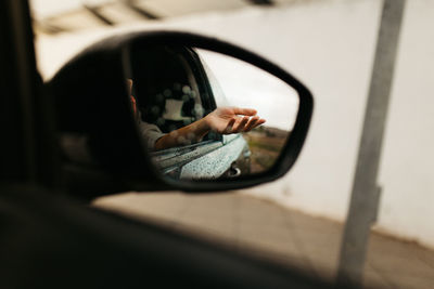 Reflection of man on side-view mirror