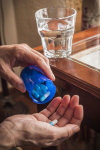 Close-up of hand holding glass of drink on table