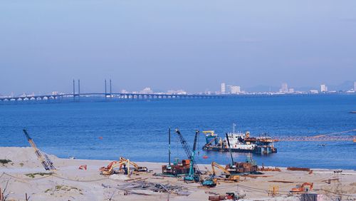 Pier over sea against sky in city