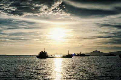 Silhouette ship sailing on sea against sky during sunset